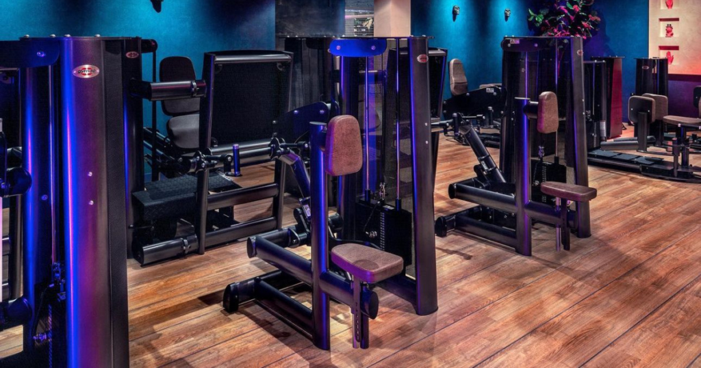 Commercial gym training floor featuring weight stack machines in comparison to plate loaded machines designed for controlled strength training and efficient workouts in modern fitness facilities.