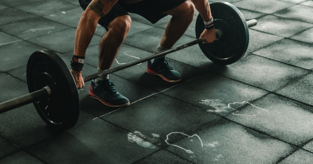 Experienced lifter preparing for a barbell strength training workout on a commercial gym floor